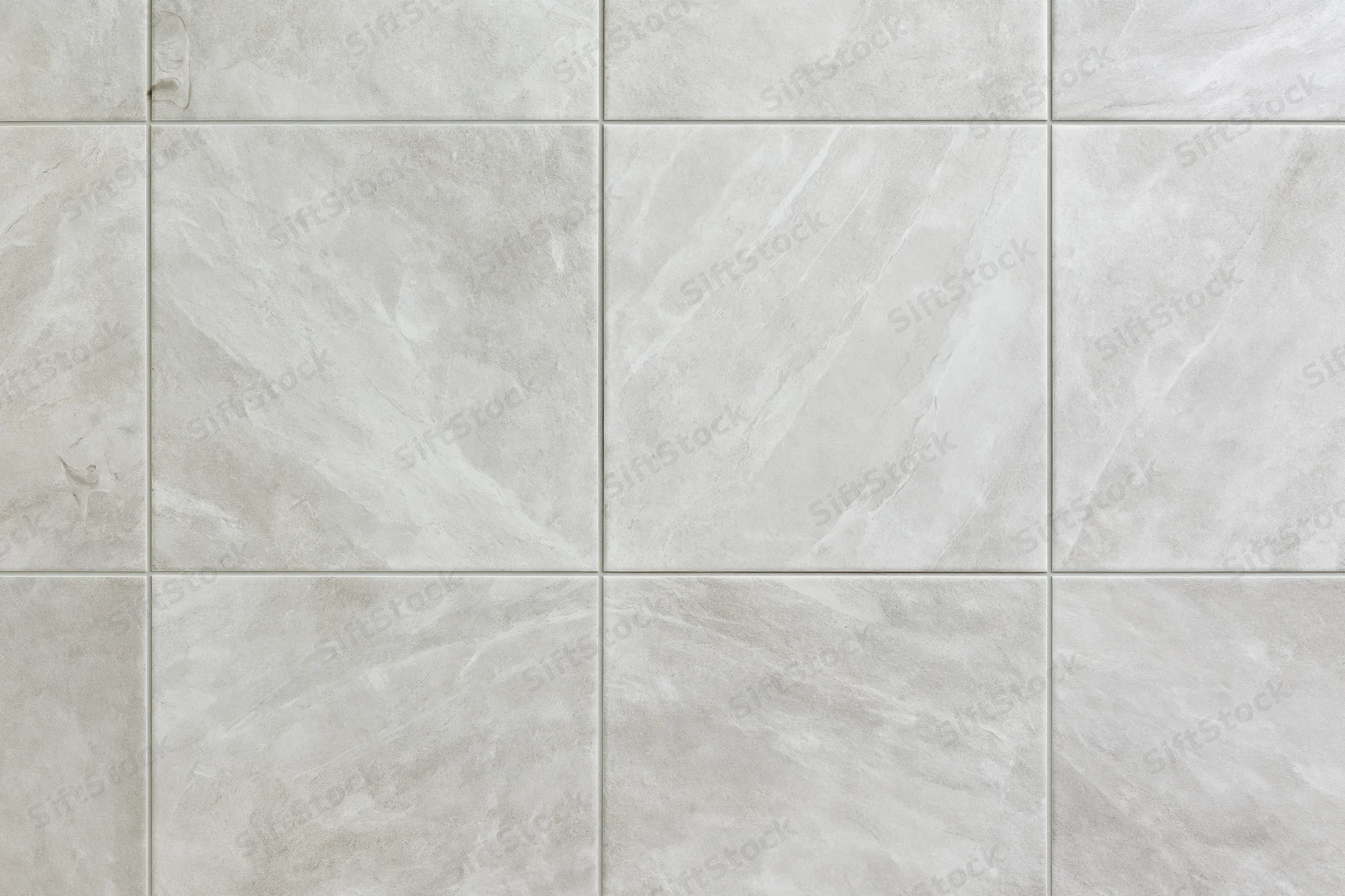 Large-format light grey ceramic floor tiles arranged in a grid pattern for interior flooring