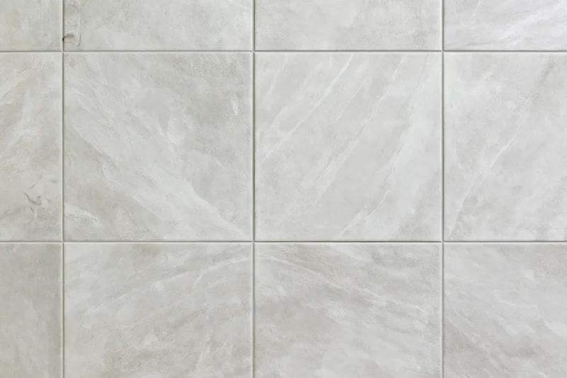 Large-format light grey ceramic floor tiles arranged in a grid pattern for interior flooring