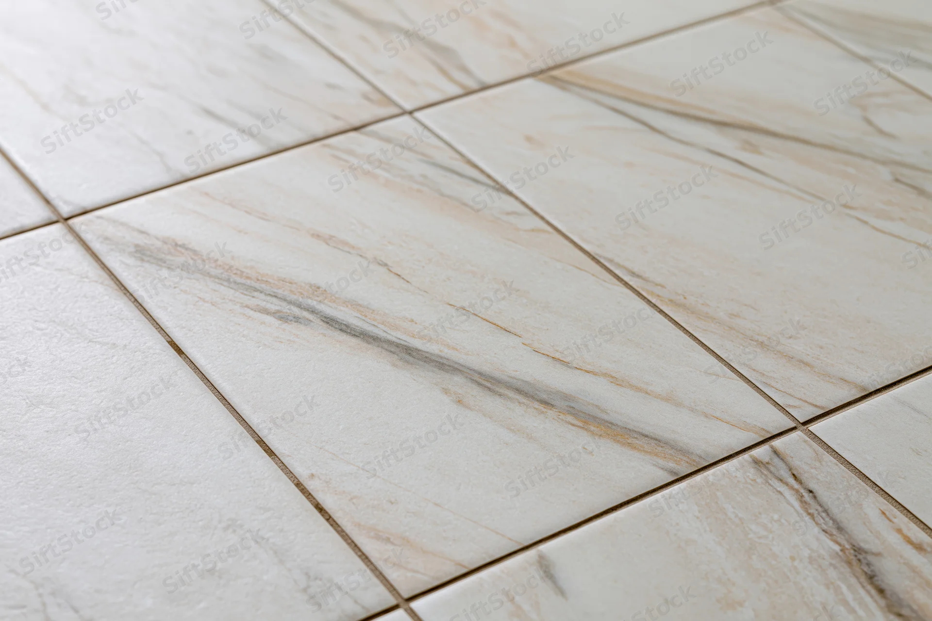Close-up of large white marble floor tiles arranged in a grid pattern with visible grout lines
