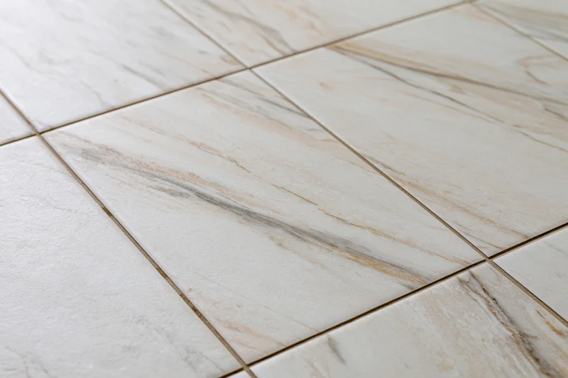 Close-up of large white marble floor tiles arranged in a grid pattern with visible grout lines
