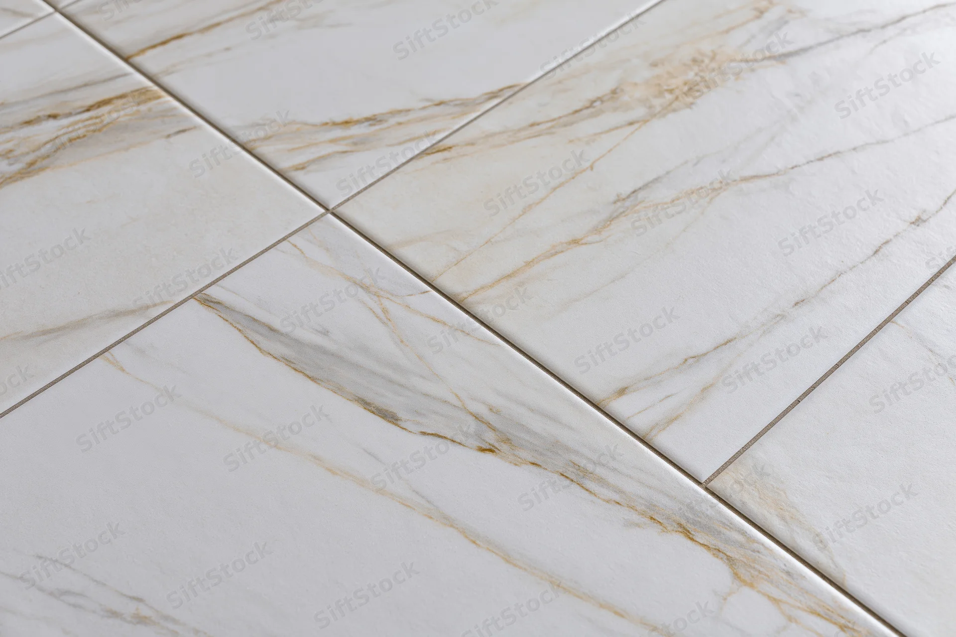 Large white marble floor tiles arranged diagonally in a close-up flat lay view