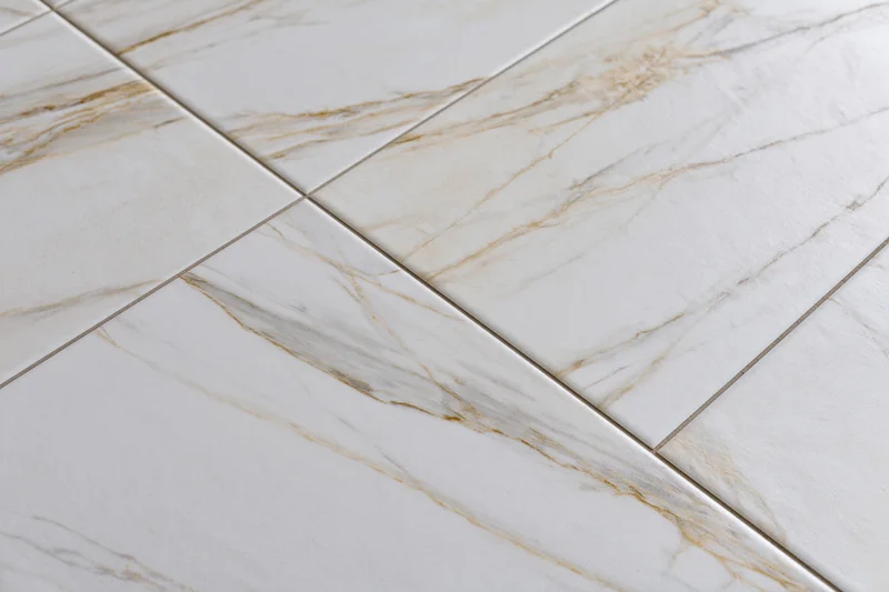 Large white marble floor tiles arranged diagonally in a close-up flat lay view