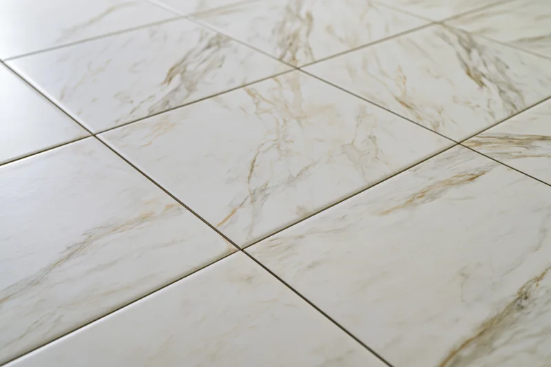 Large white marble floor tiles arranged in a grid pattern with visible grout lines