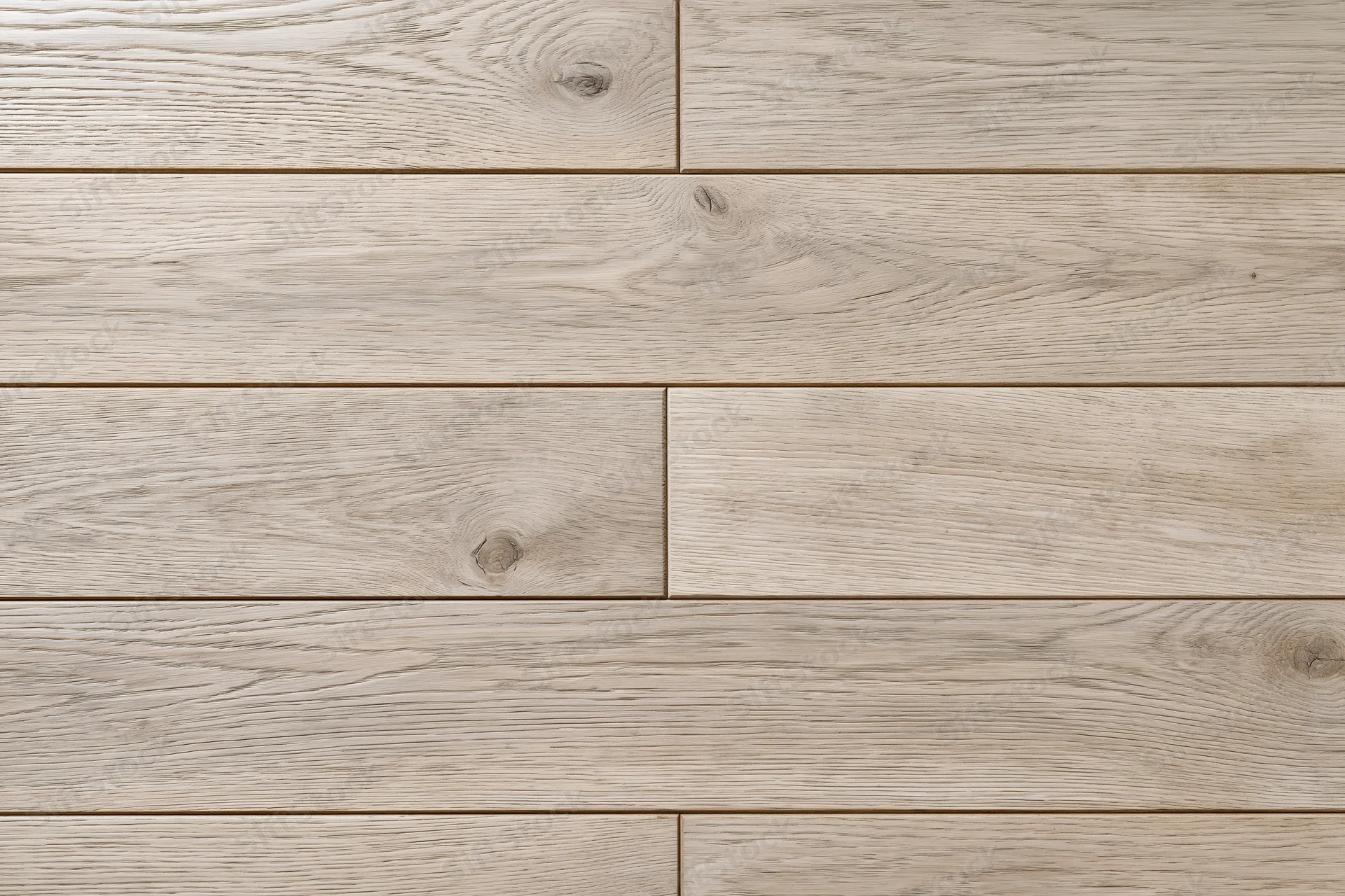 Close-up flat lay of light grey-beige hardwood floor planks arranged in staggered pattern for interior flooring application