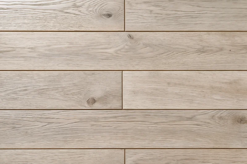 Close-up flat lay of light grey-beige hardwood floor planks arranged in staggered pattern for interior flooring application