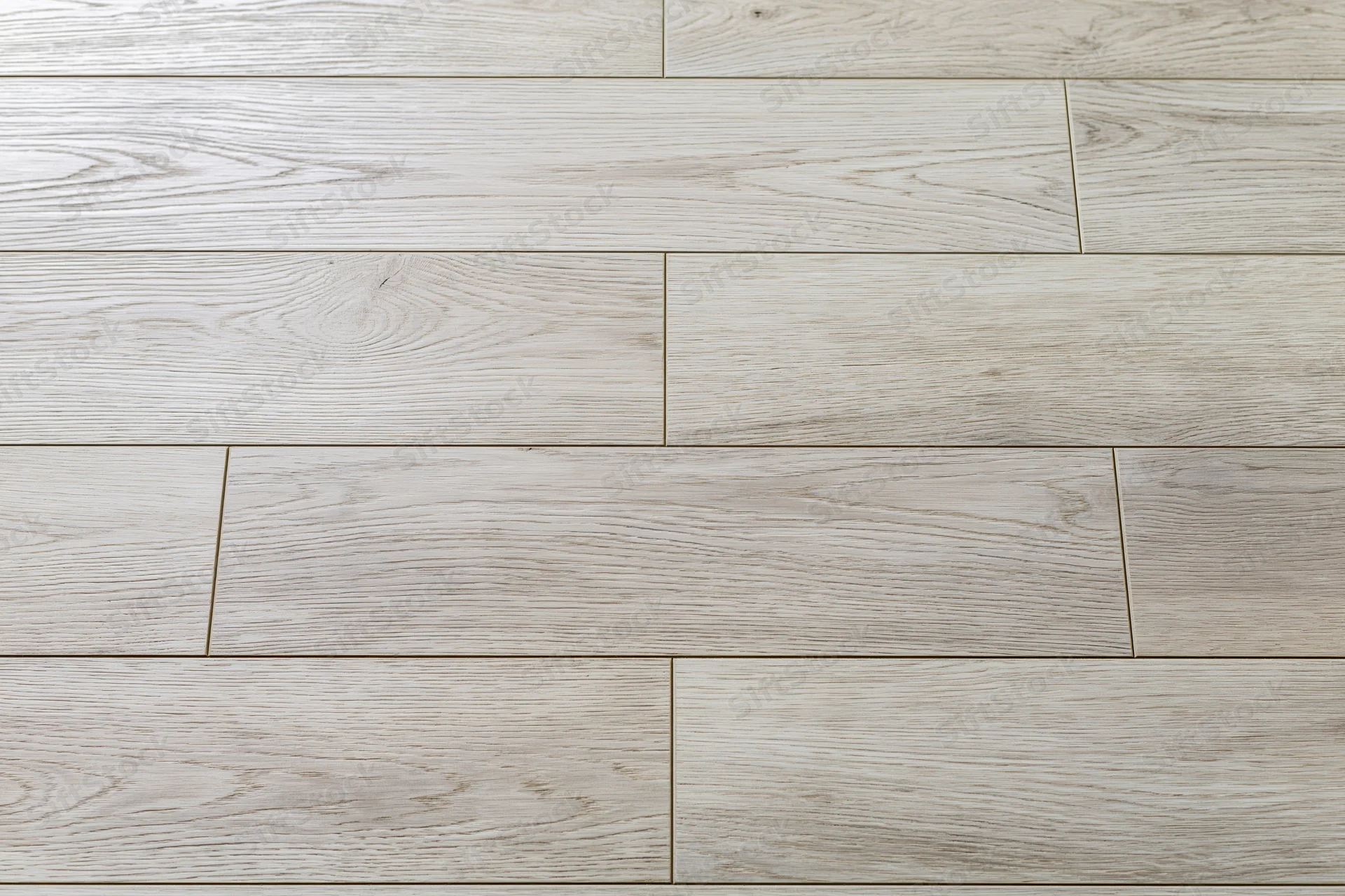 Close-up flat lay of light grey-beige oak hardwood flooring planks arranged in staggered pattern on interior floor surface