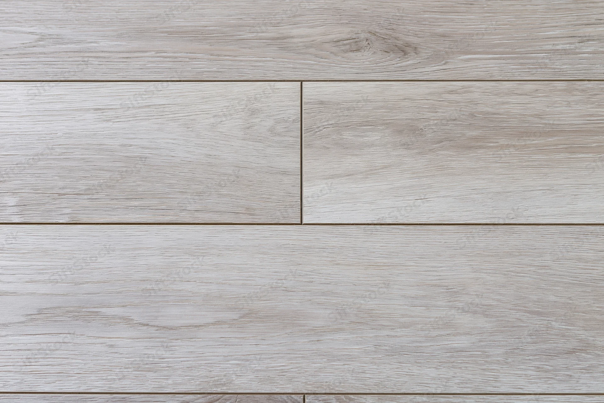 Close-up flat lay of light grey-beige oak hardwood flooring planks arranged in horizontal rows with visible wood grain and joints