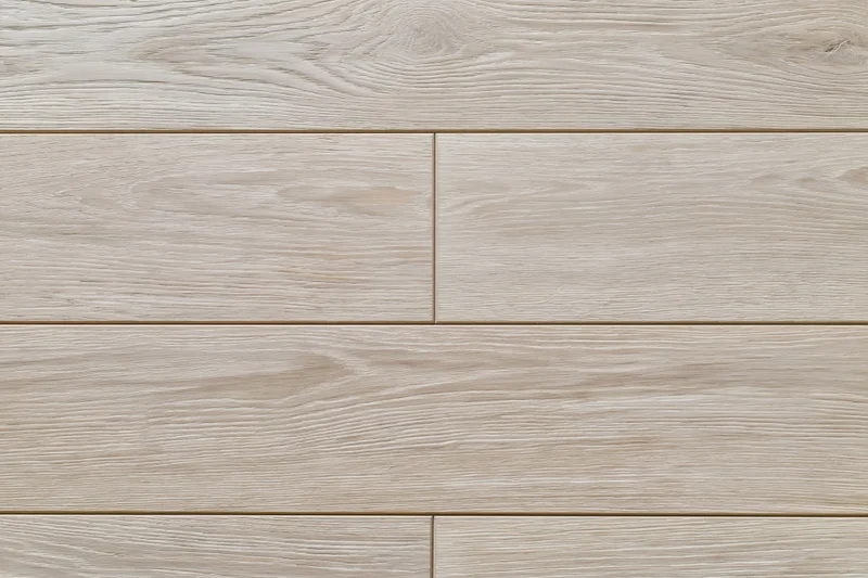 Close-up flat lay of light grey-beige oak hardwood flooring planks arranged in staggered pattern on interior floor surface