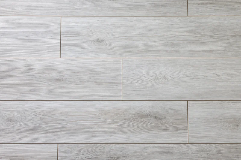 Light grey oak laminate flooring planks arranged in a flat lay pattern for interior design