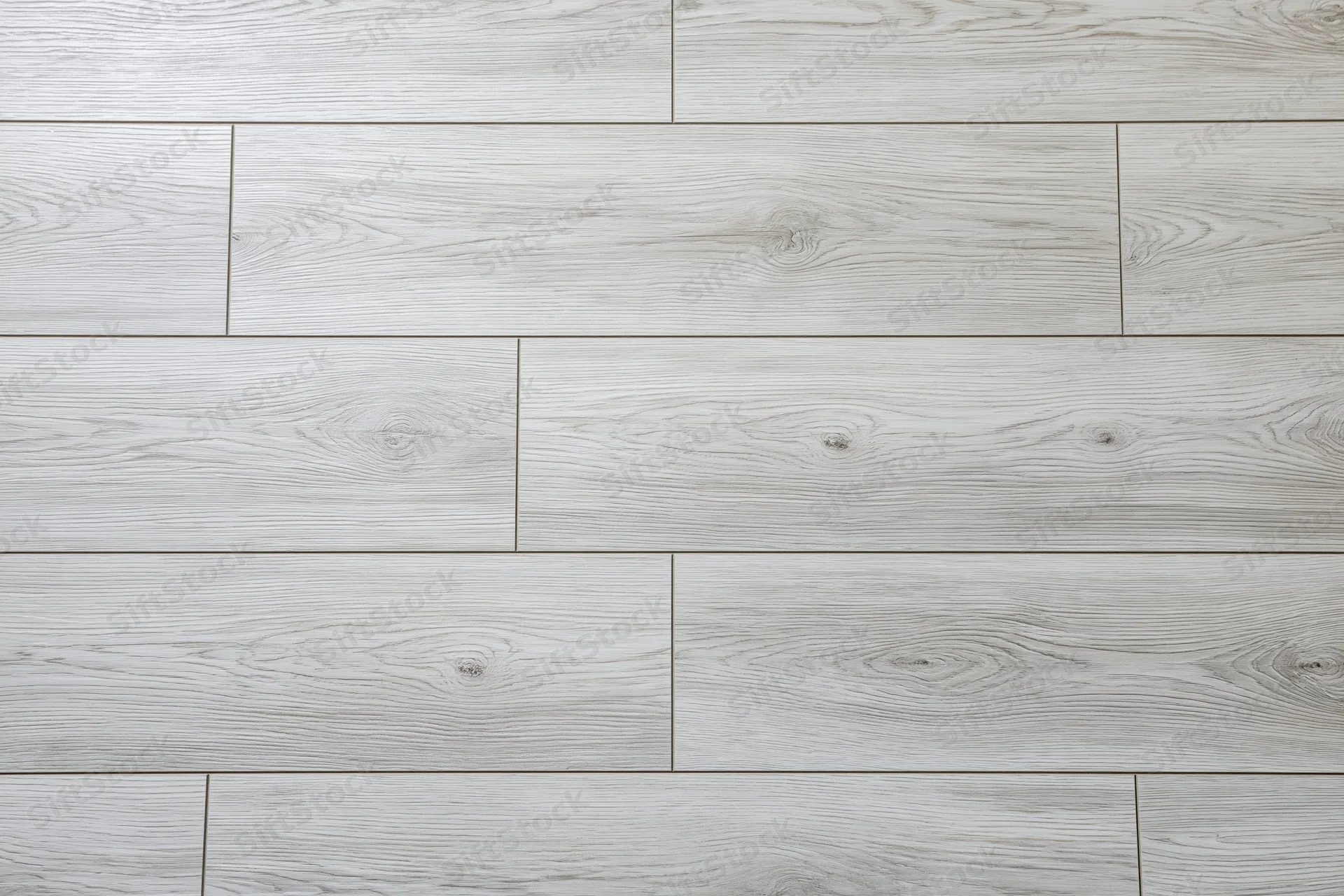Light grey oak laminate flooring planks arranged in staggered pattern for interior flooring