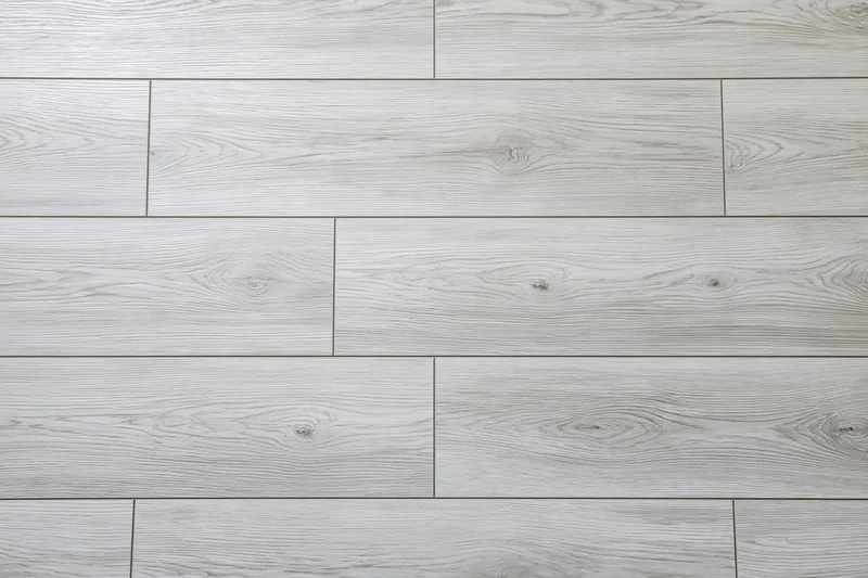 Light grey oak laminate flooring planks arranged in staggered pattern for interior flooring