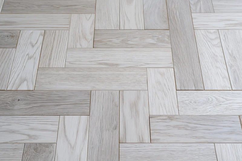 Close-up of light grey whitewashed oak parquet floor arranged in herringbone pattern