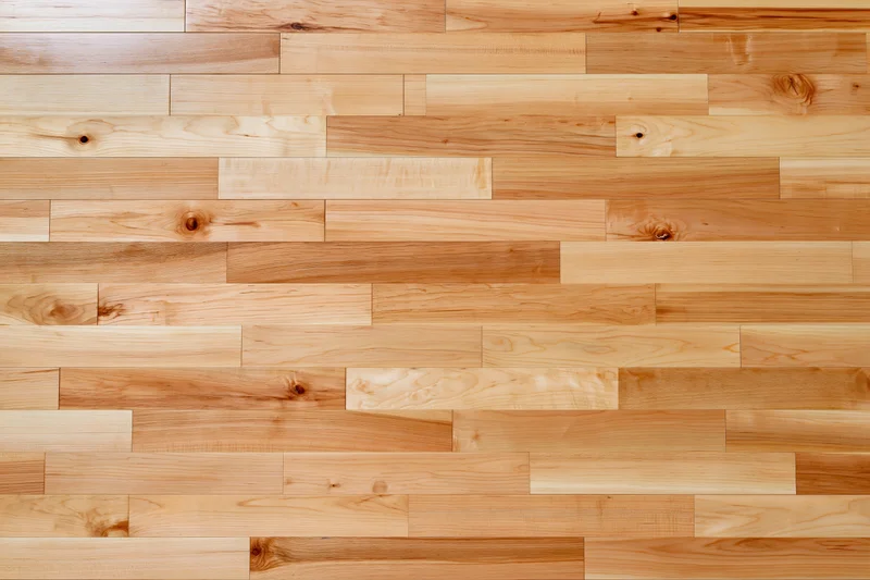 Light hardwood parquet flooring arranged in staggered planks filling the frame