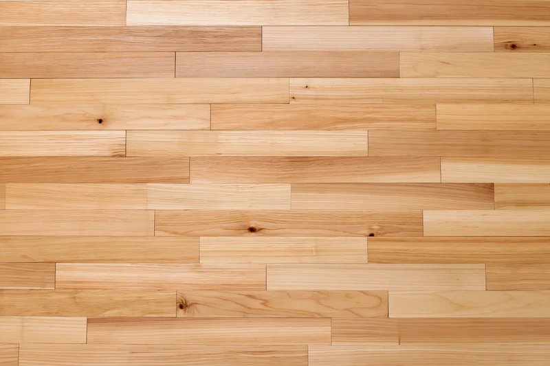 Light hardwood parquet flooring arranged in staggered planks filling the frame