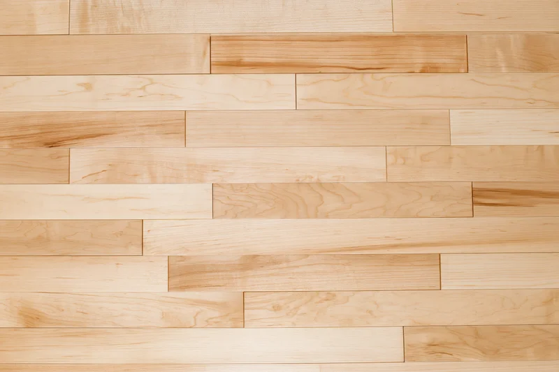 Close-up of light maple hardwood floor planks arranged horizontally in a seamless pattern