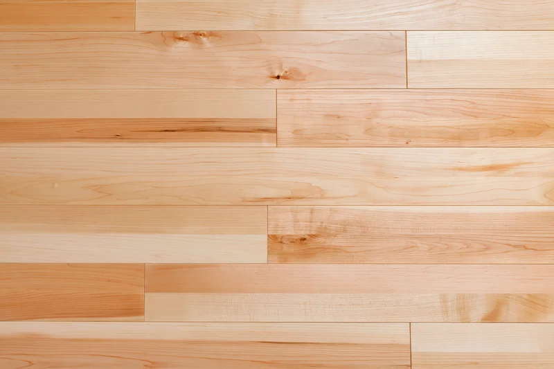 Light maple hardwood flooring planks arranged in a seamless pattern for interior use