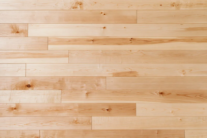 Light maple hardwood flooring planks arranged in horizontal rows for interior flooring