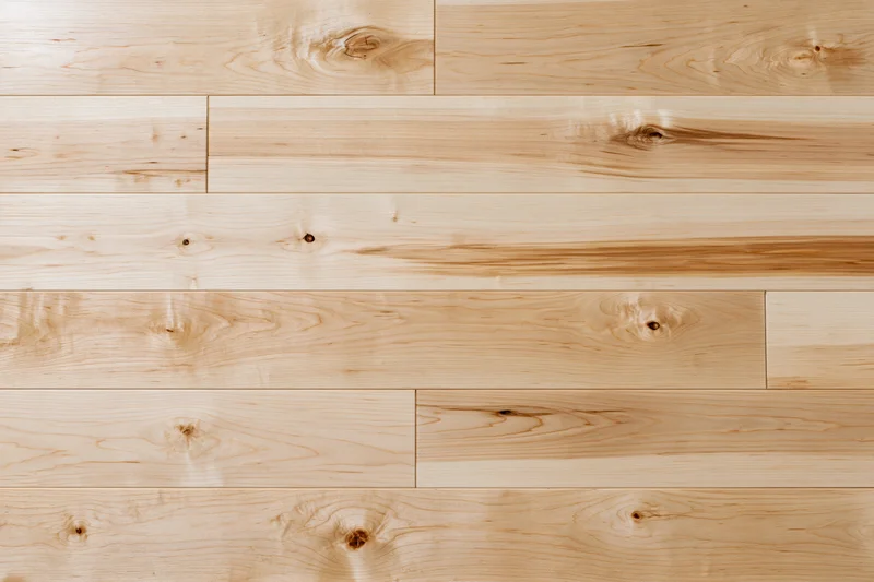 Light maple hardwood flooring planks arranged in horizontal rows for interior flooring