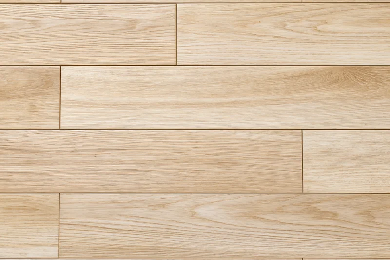 Light oak hardwood floor planks arranged in staggered pattern for interior flooring