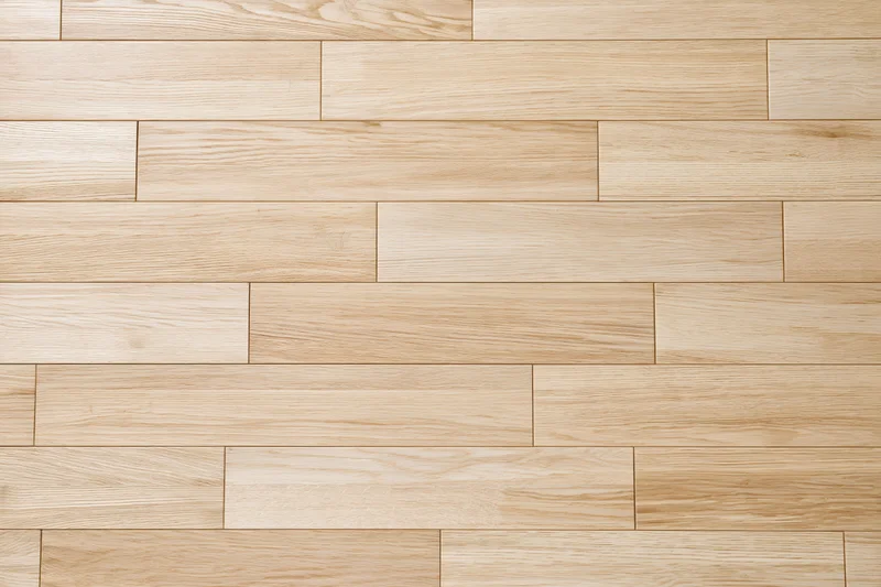 Light oak hardwood floor planks arranged in staggered pattern for interior flooring