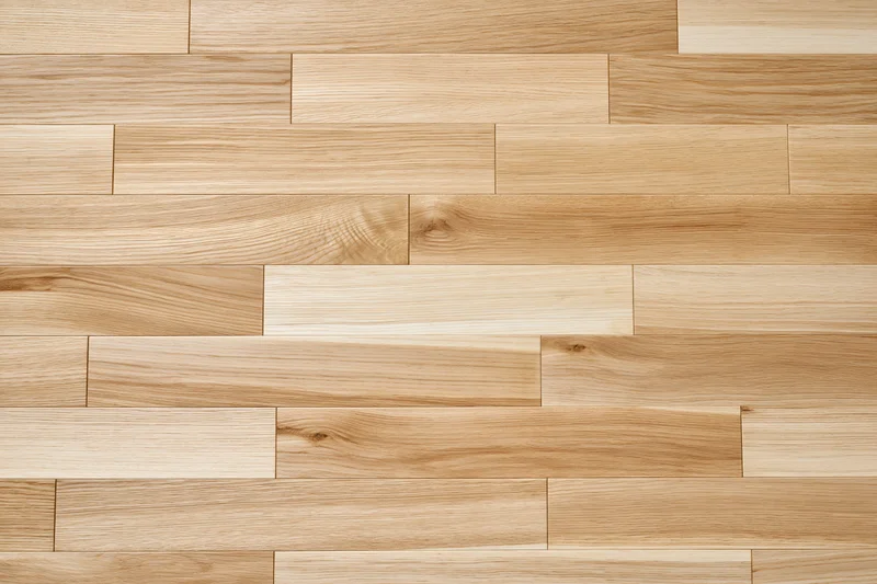 Light oak hardwood flooring planks arranged in staggered pattern on flat surface