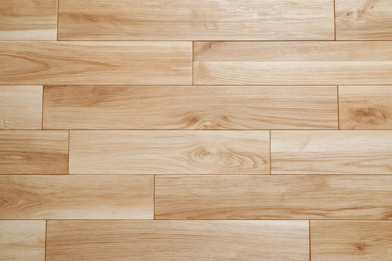 Light oak hardwood flooring planks arranged in staggered pattern for interior flooring