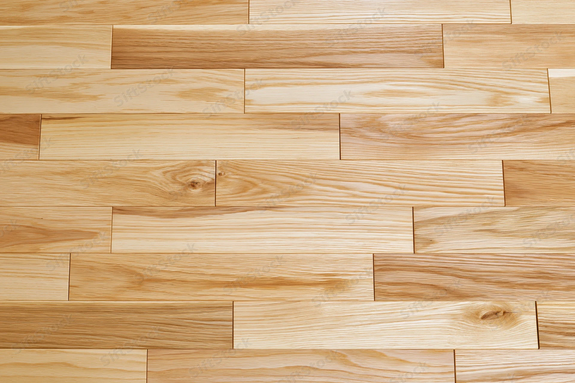 Light oak hardwood flooring planks arranged in staggered pattern for interior flooring