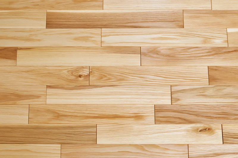 Light oak hardwood flooring planks arranged in staggered pattern for interior flooring