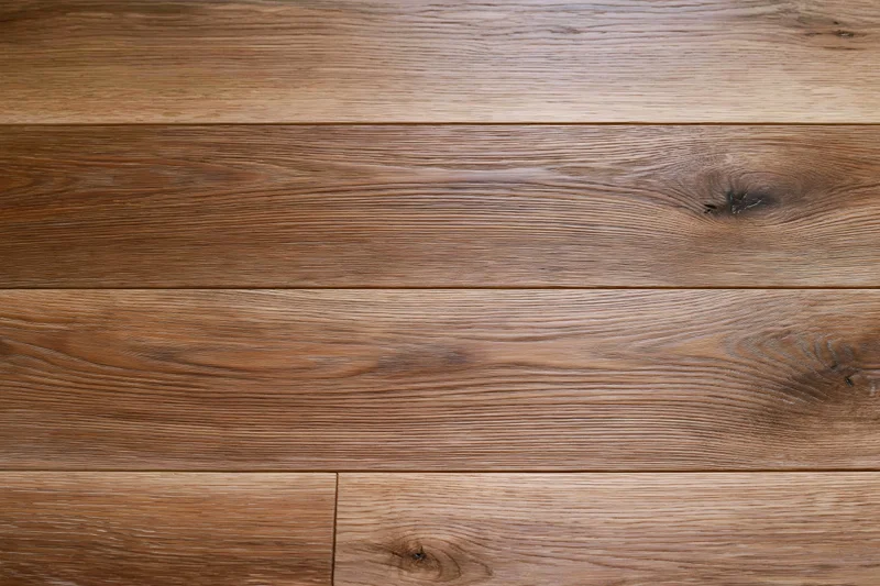 Close-up of medium brown oak hardwood flooring planks arranged in horizontal rows on a flat surface