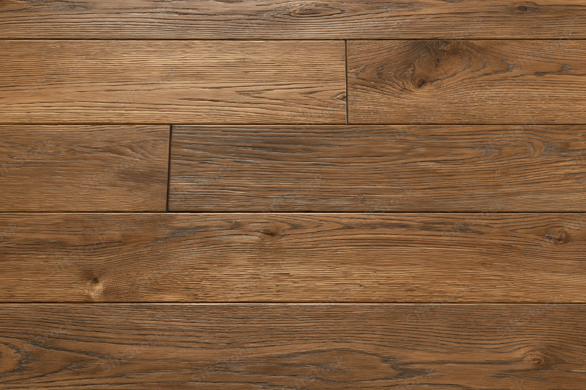 Medium brown oak hardwood flooring planks arranged in a flat lay pattern on an indoor floor surface