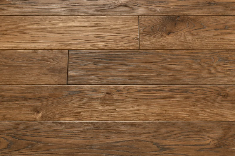 Medium brown oak hardwood flooring planks arranged in a flat lay pattern on an indoor floor surface
