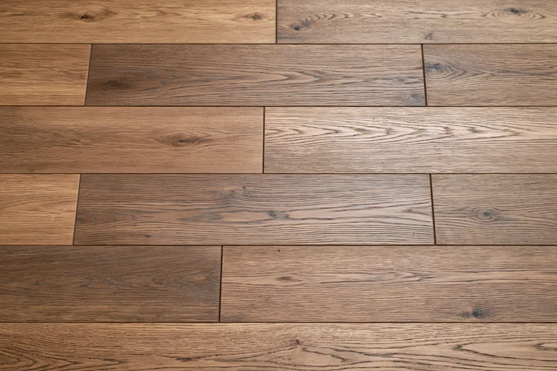 Medium brown oak hardwood flooring planks arranged in a staggered pattern on a flat surface