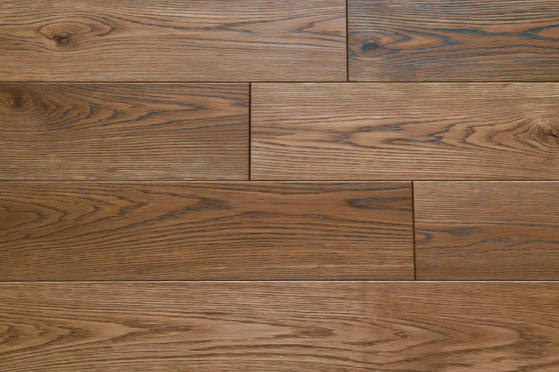Close-up flat lay of medium brown oak hardwood flooring planks arranged in staggered pattern