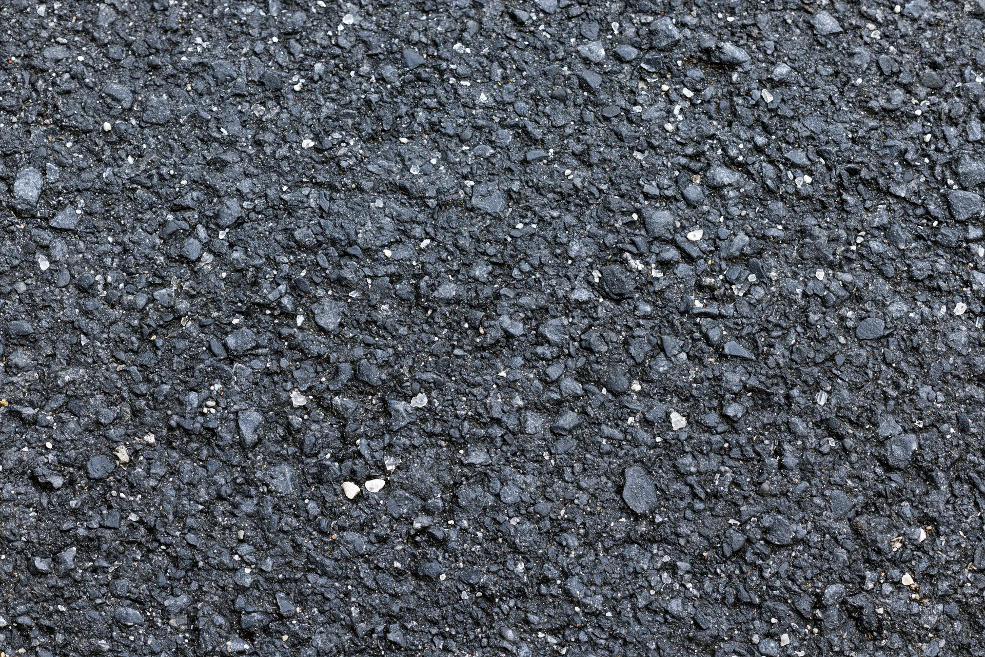 Close-up flat lay of rough asphalt pavement surface filling frame