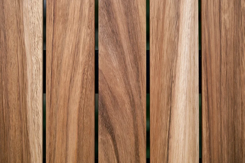Vertical teak wood planks arranged side by side in a flat lay close-up view