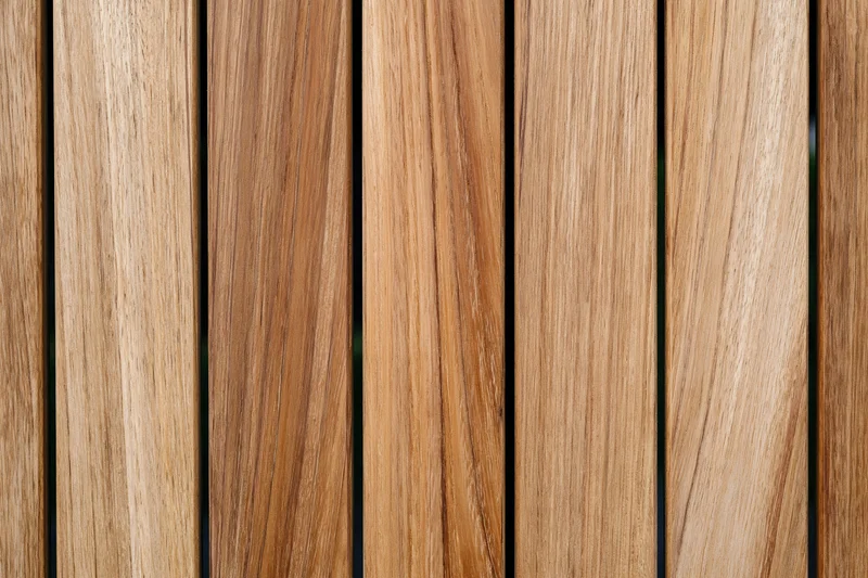 Vertical teak wood planks arranged side by side in a flat lay closeup