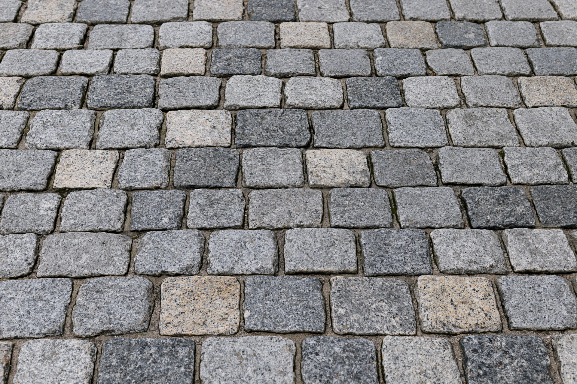 Cobblestone pavement surface arranged in a grid pattern viewed from directly above