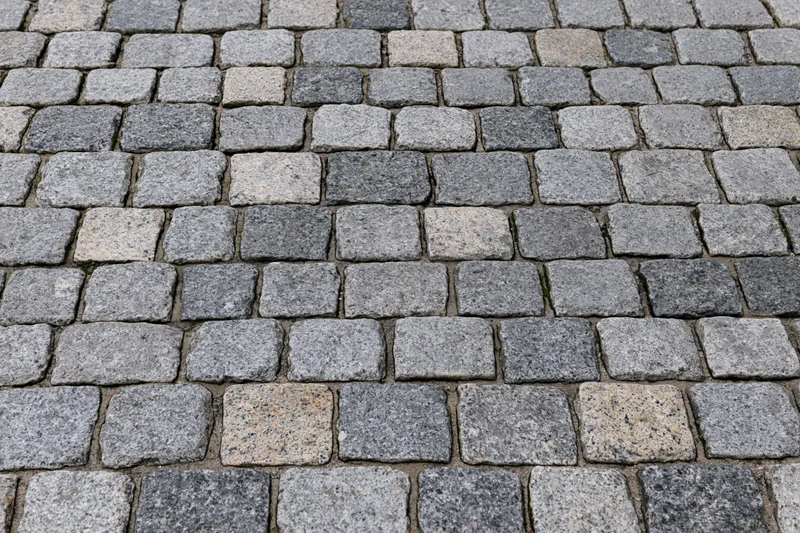 Cobblestone pavement surface arranged in a grid pattern viewed from directly above