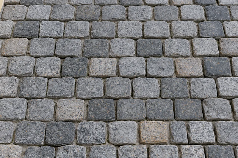 Close-up overhead view of gray cobblestone pavement surface arranged in rows