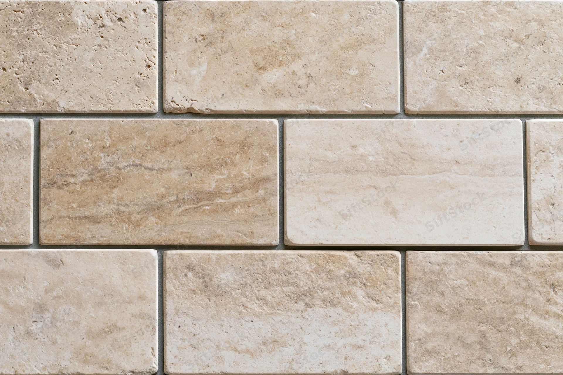 Rectangular travertine stone tiles arranged in staggered rows on a wall surface
