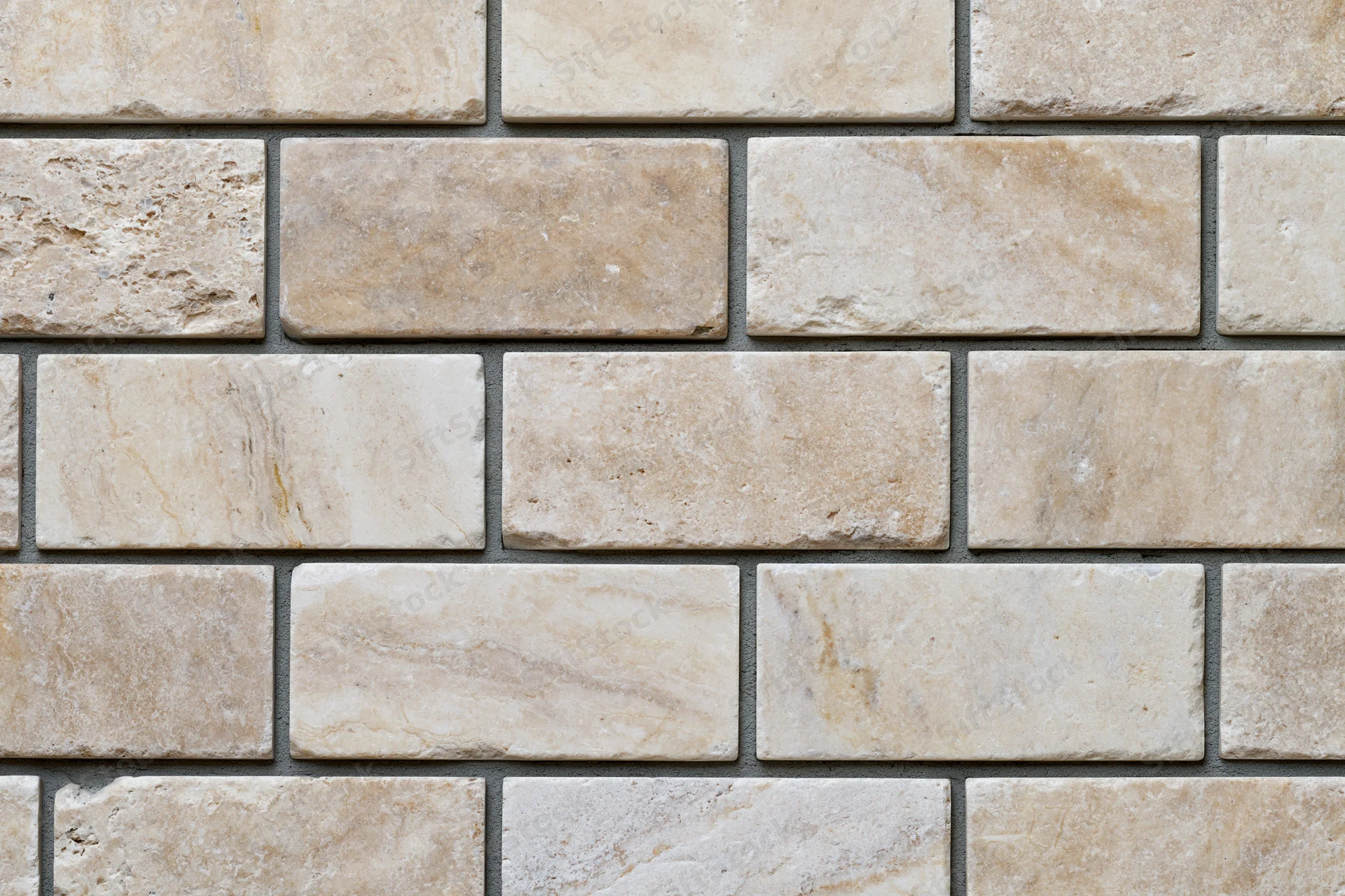 Close-up flat shot of rectangular travertine stone tiles in staggered pattern on wall