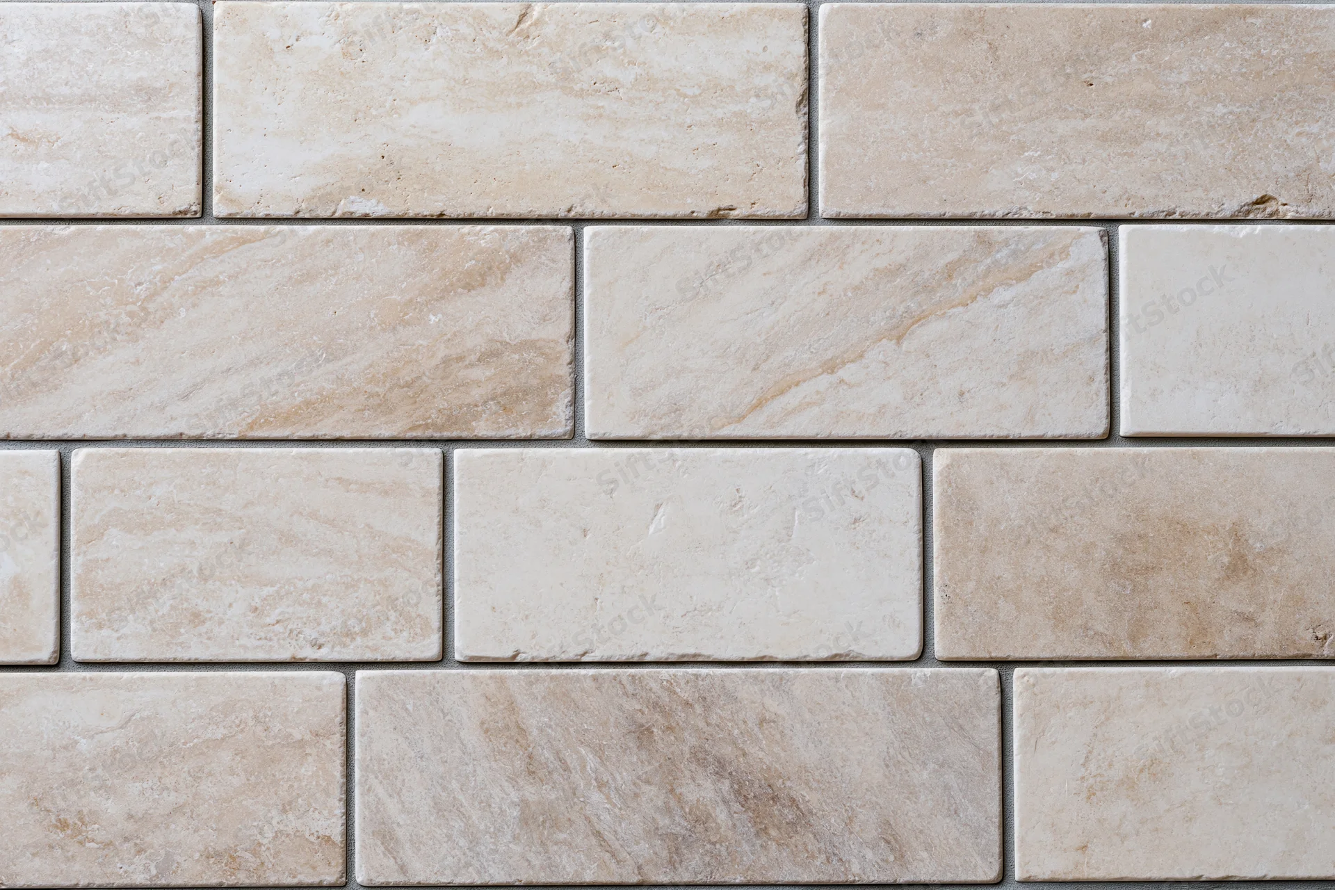 Rectangular travertine stone tiles arranged in staggered rows on a wall surface