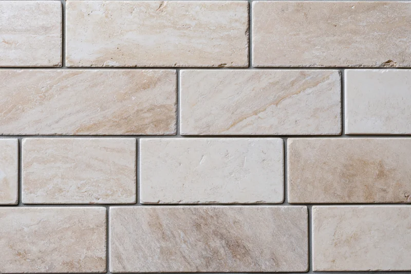 Rectangular travertine stone tiles arranged in staggered rows on a wall surface