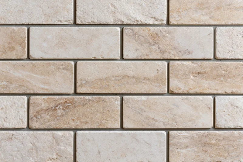 Rectangular travertine stone tiles arranged in a staggered pattern on a wall surface