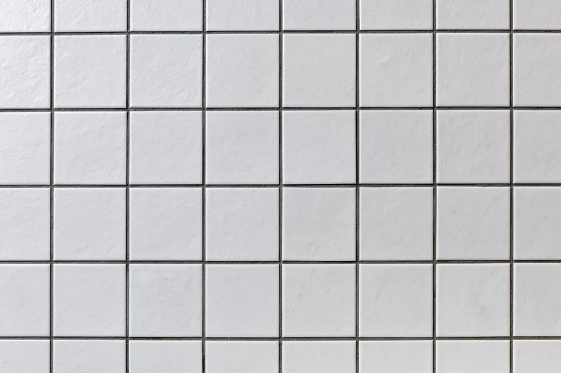 White ceramic tiles arranged in a grid pattern on a wall