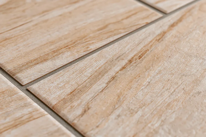 Diagonal ceramic floor tiles with wood grain texture arranged in a flat surface