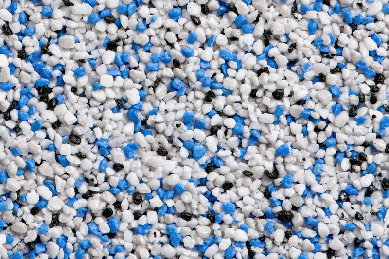Close-up of mixed plastic polymer granules scattered across a flat surface