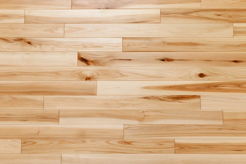Light hardwood parquet flooring arranged in horizontal planks with natural wood grain and knots, viewed from overhead flat lay