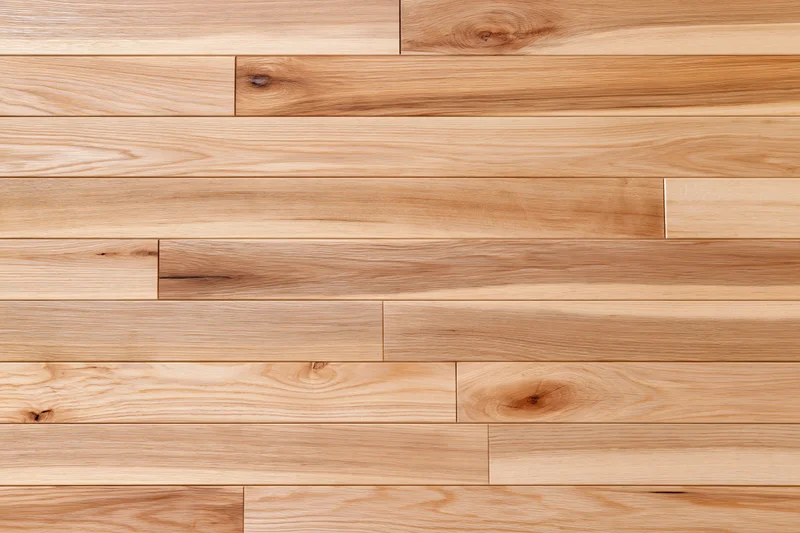 Light hardwood parquet flooring arranged in horizontal planks with natural wood grain and knots, viewed from overhead flat lay