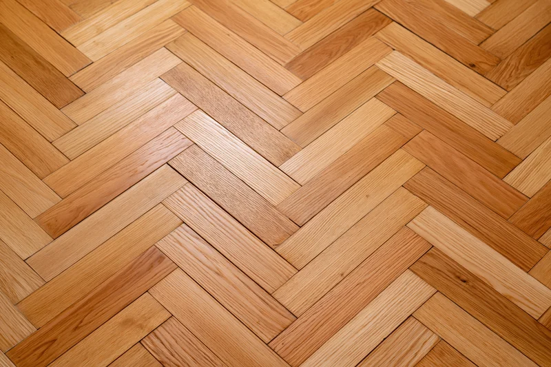 Herringbone parquet wood floor with natural grain pattern in interior space
